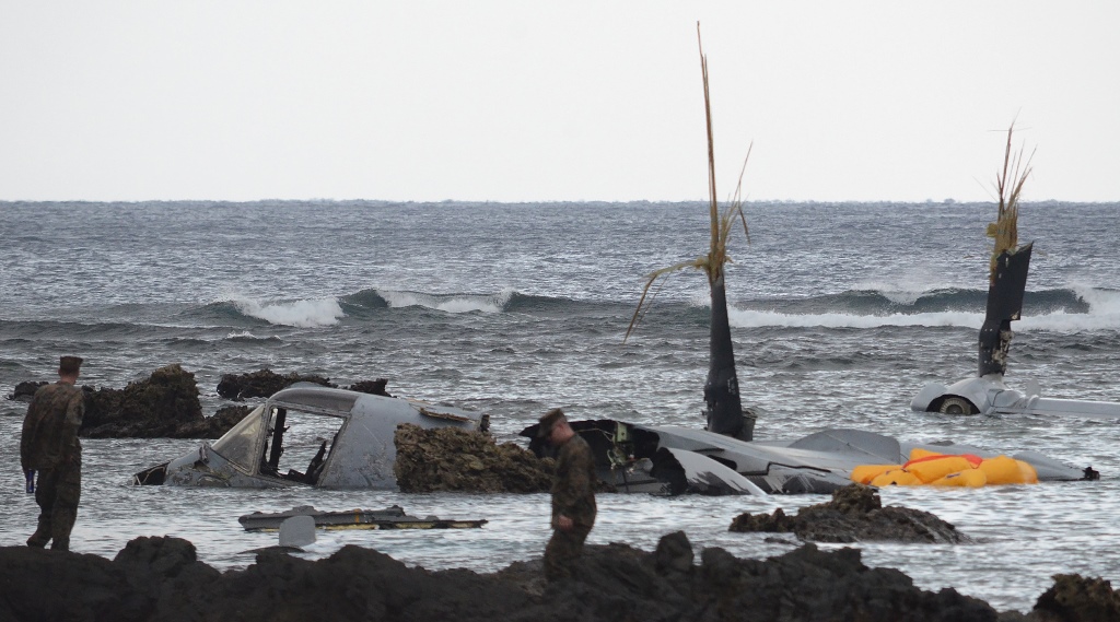 The wreckage of a US Marine MV-22 Osprey tilt-rotor aircraft is seen as the tide recedes on the coast of Nago, Japan's southern island of Okinawa on December 14, 2016, after it crash landed in shallow waters late December 13. Japan OUT / AFP / JIJI PRESS 