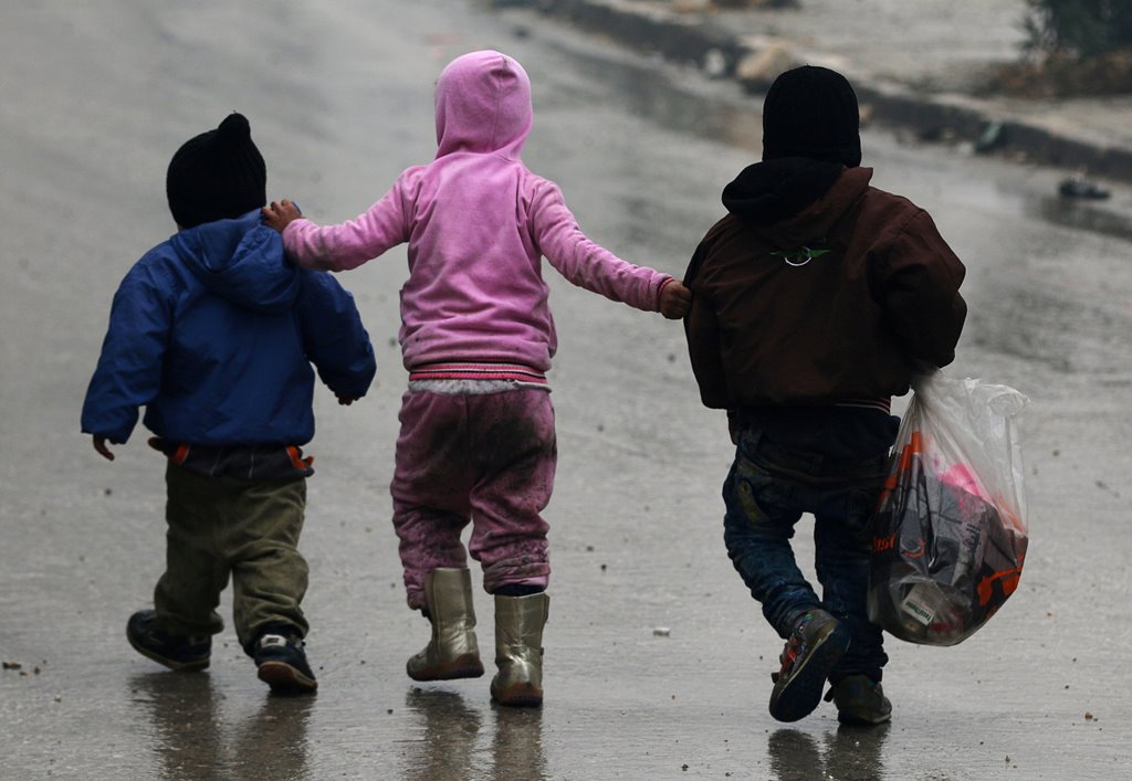 Children walk together as they flee deeper into the remaining rebel-held areas of Aleppo, Syria December 13, 2016. REUTERS/Abdalrhman Ismail 