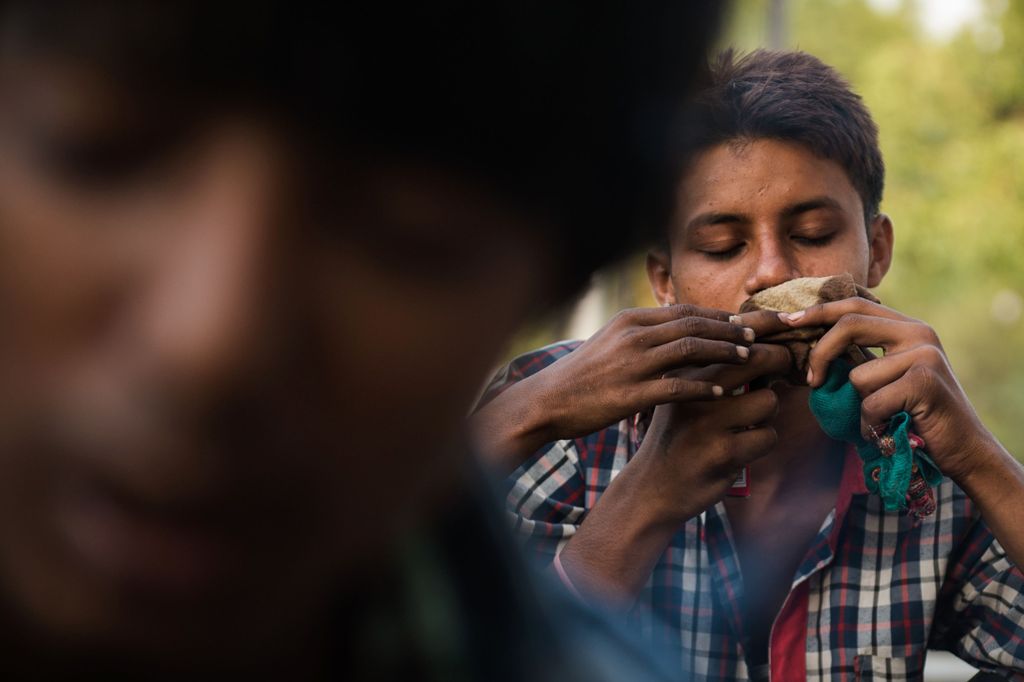 (FILES) In this photograph taken on September 7, 2015, an Indian youth who works as a ragpicker sniffs a cloth soaked in glue near the Hazrat Nizamuddin Railway station in New Delhi.  AFP
