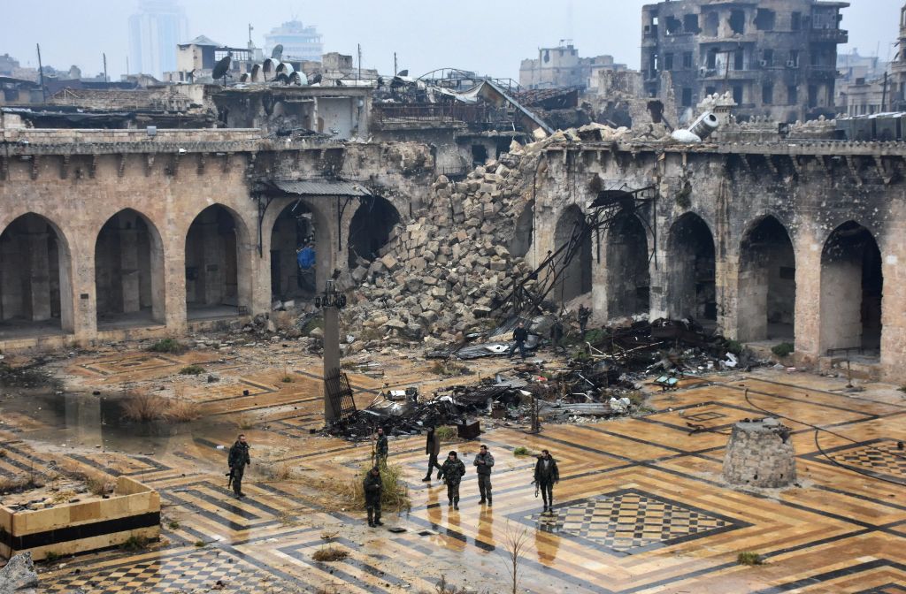 A general view shows Syrian pro-government forces walking in the ancient Umayyad mosque in the old city of Aleppo on December 13, 2016, after they captured the area. After weeks of heavy fighting, regime forces were poised to take full control of Aleppo, 