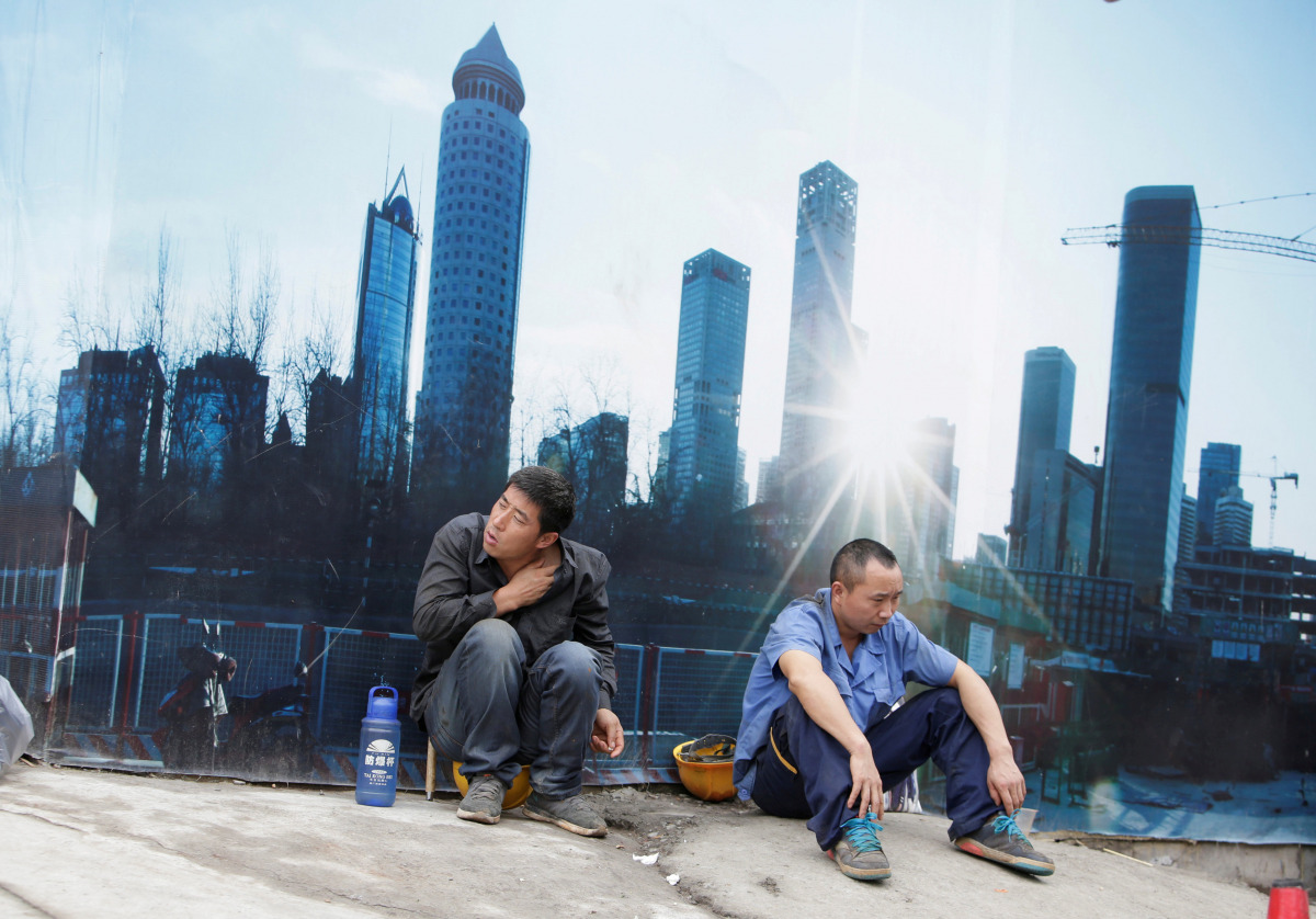 FILE PHOTO: Workers rest outside a construction site in Beijing's central business district, China, July 15, 2016. REUTERS/Jason Lee