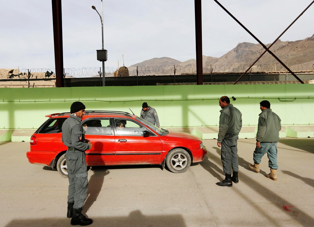 Afghan policemen inspect passengers at a Kabul entrance gate checkpoint in Kabul, Afghanistan December 7, 2016. REUTERS/Mohammad Ismail
