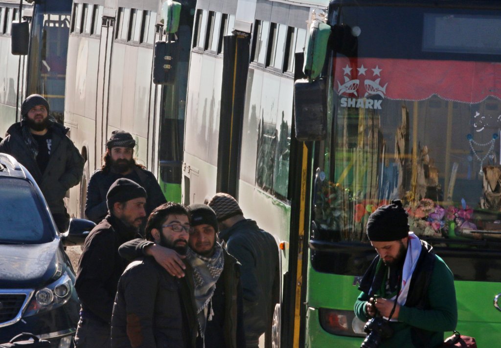 Men react as they stand outside buses evacuating people from a rebel-held sector of eastern Aleppo, Syria December 15, 2016. REUTERS/Abdalrhman Ismail
