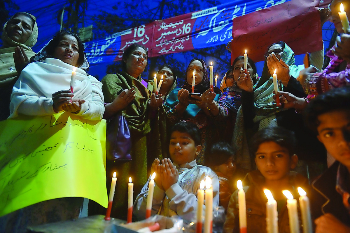 Residents hold lighted candles during a ceremony in Lahore yesterday to pay tribute to victims on the second anniversary of an attack on the Army Public School in Peshawar.