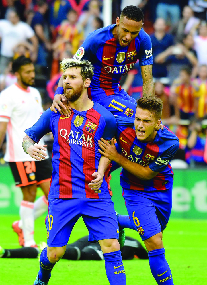 Barcelona's Lionel Messi (left) celebrates with Neymar (up) and Denis Suarez after scoring a goal against Valencia during their La Liga match in this file 
photo of October 23, 2016.