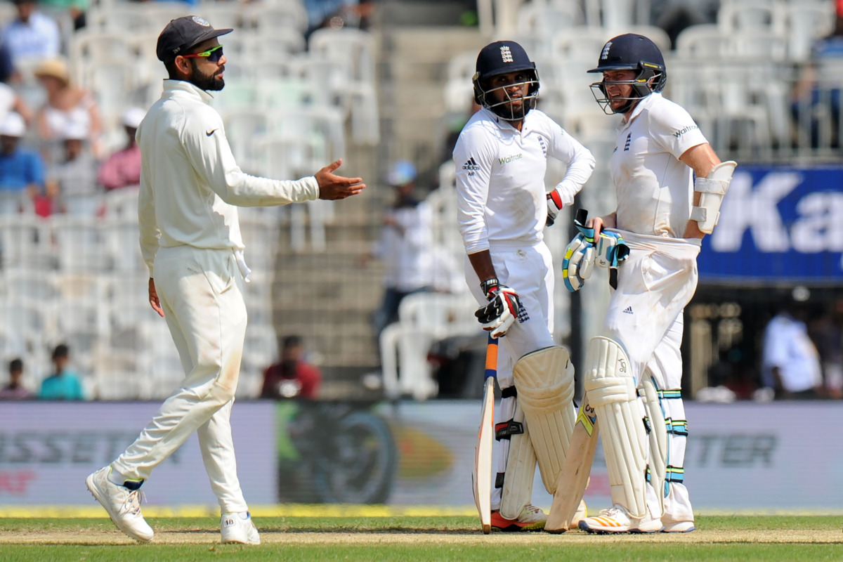 England's Liam Dawson (R) speaks with teammate Adil Rashid (C) as India's captain Virat Kohli (R) gestures during the second day of the fifth and final Test cricket match between India and England at The M.A. Chidambaram Stadium in Chennai on December 17,