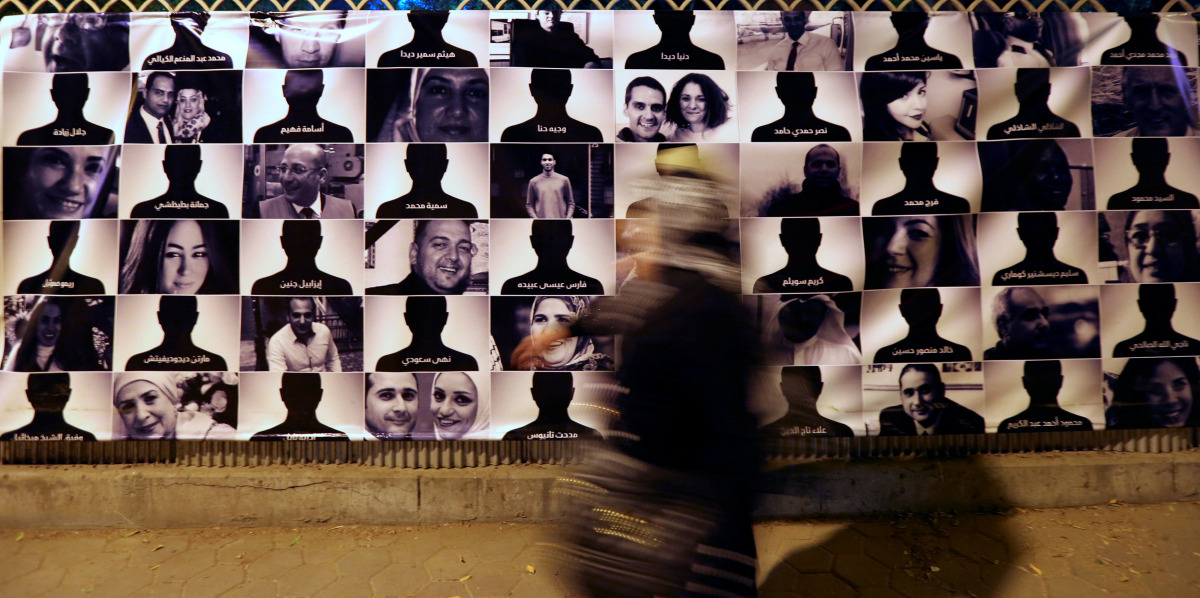 A woman passes by photos of EgyptAir flight 804 victims at the Cairo Opera House, May 26, 2016 (REUTERS / Mohamed Abd El Ghany) 