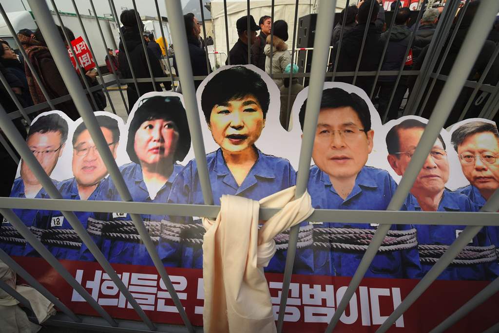 Portraits of South Korea's President Park Geun-Hye (C) and her aides are set in a mock prison during a rally against the scandal-hit president in central Seoul on December 17, 2016. AFP / JUNG Yeon-Je
