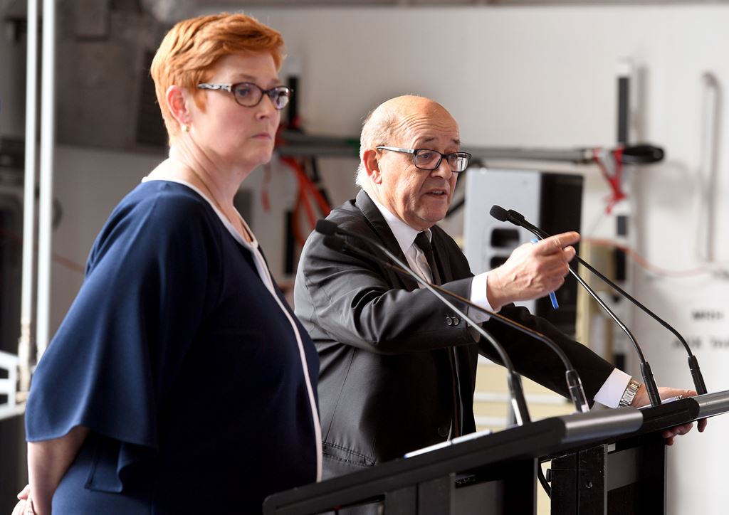 France's Minister of Defence Jean-Yves Le Drian (R) gestures beside his Australian counterpart Marise Payne as they address the media on the hangar deck of the HMAS Adelaide in Sydney on December 19, 2016. AFP / William West