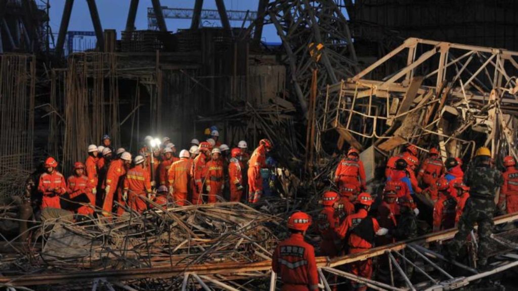 Workers search through the remains of a collapsed platform in a cooling tower at a power station at Fengcheng in China's Jiangxi province on November 24, 2016. The death toll from a collapse at a power station under construction in China rose to 74, state