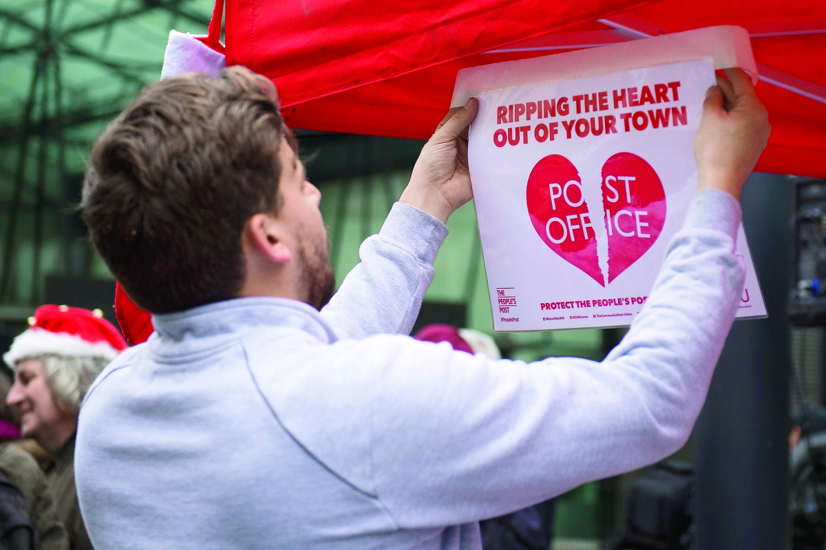 A member of the Communication Workers Union (CWU) takes part in a picket outside the Department for Business, Innovation and Skills in London yesterday.
