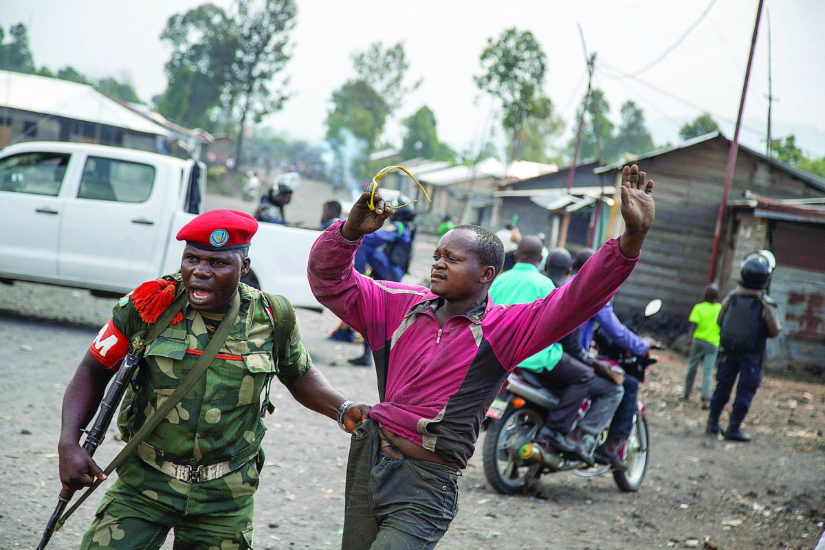A man is arrested by a member of the military police after people attempted to block the road with rocks, in the neighbourhood of Majengo in Goma, eastern DR Congo, yesterday.