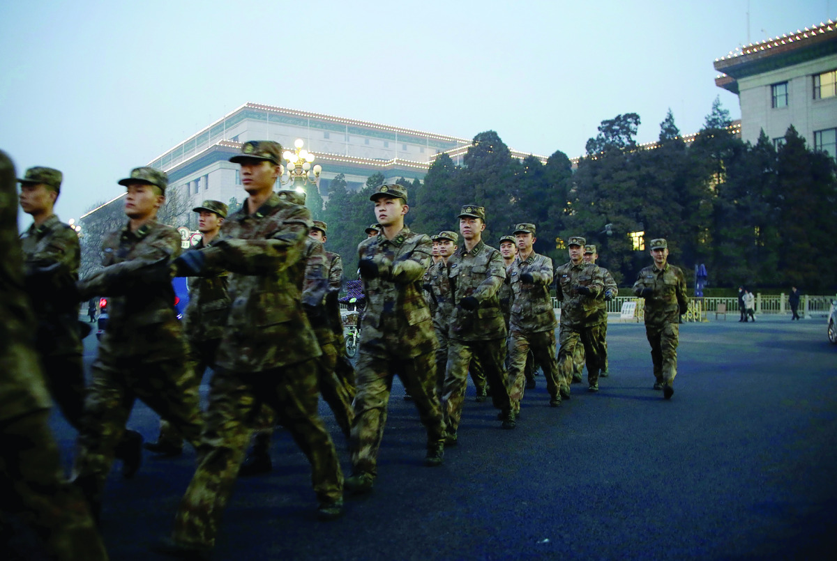 Soldiers patrol outside the Great Hall of the People on the fourth day after a red alert was issued for heavy air pollution in Beijing, yesterday. 