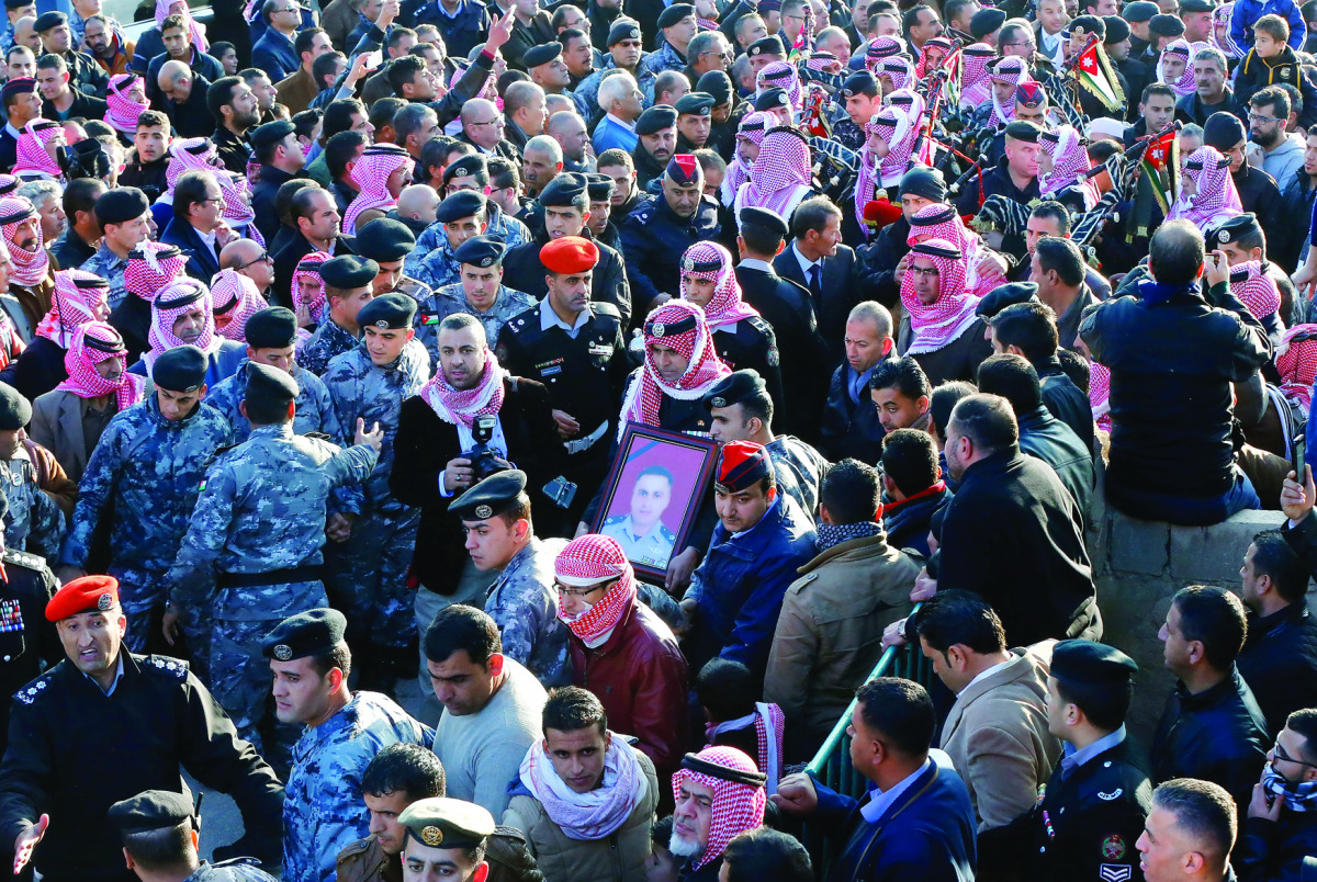 Jordanians carry a picture of Lt Colonel Saed Mayateh, who was killed in the attack on Sunday, during his funeral in the city of Karak, yesterday.