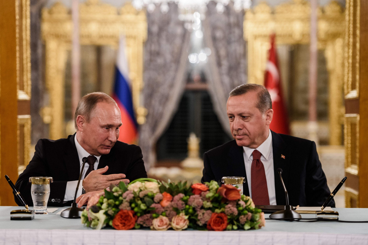 This file photo taken on October 10, 2016 shows Russian President Vladimir Putin (L) speaking to Turkish President Recep Tayyip Erdogan (R) as they attend a press conference in Istanbul. Veteran diplomat Andrei Karlov was shot nine times in the back by an