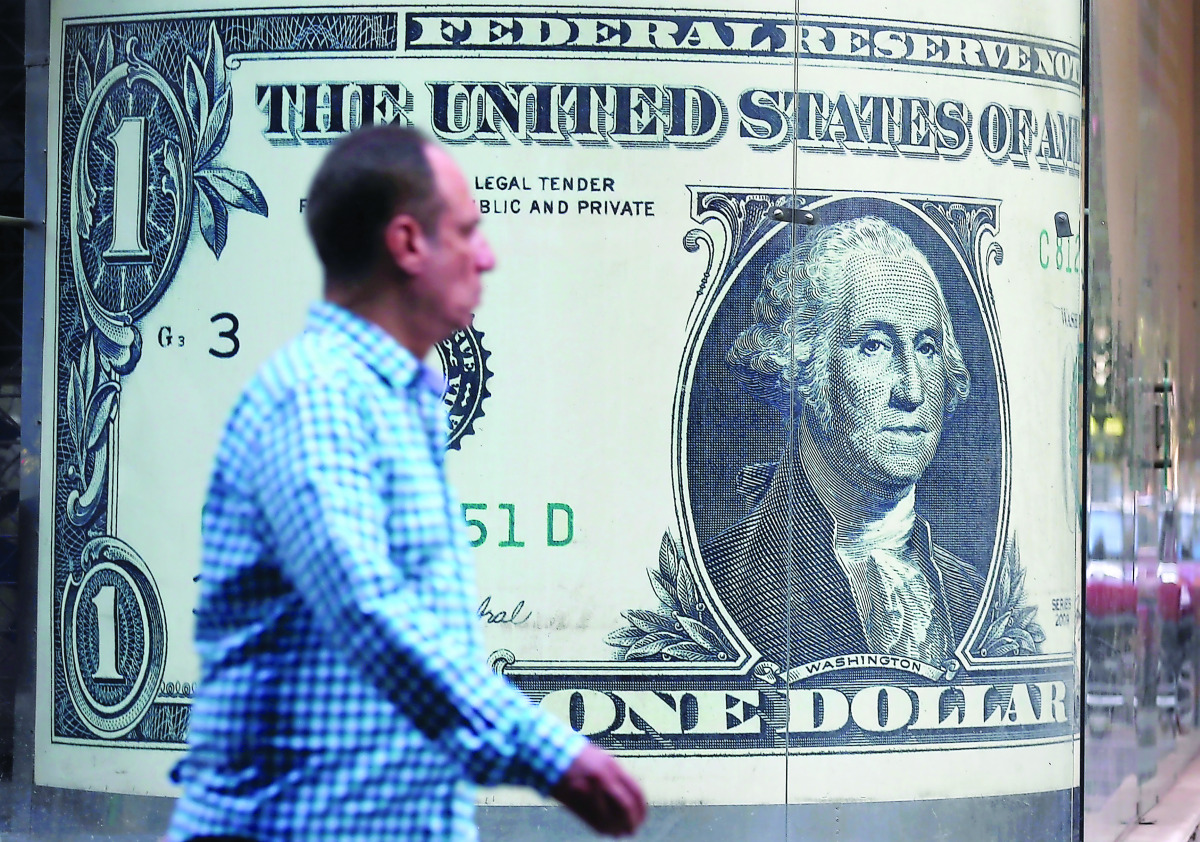 A man walks past a currency exchange bureau advertisement showing an image of the US dollar, in Cairo yesterday.