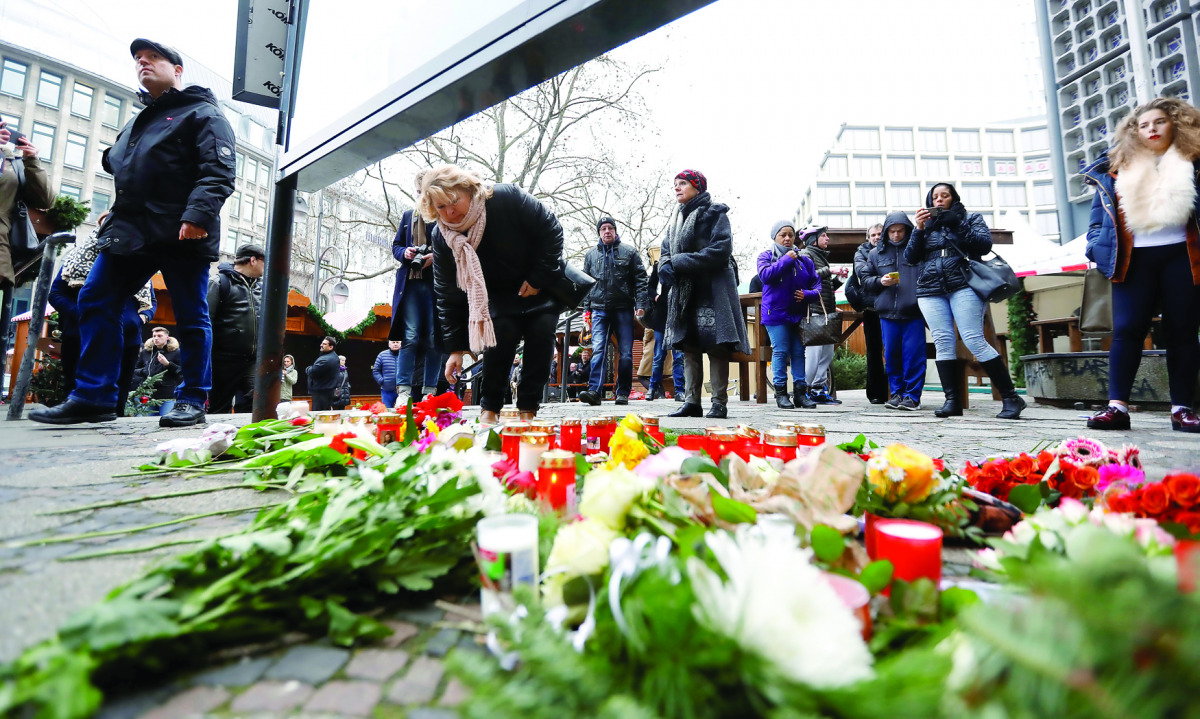 People gather to lay down flowers for the deceased outside the Gedaechniskirche.