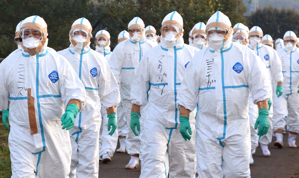 Quarantine officials in protective gears head to a poultry farm in Kawaminami, Miyazaki Prefecture, southwestern Japan to bury chickens culled after a highly virulent strain of bird flu was detected in this photo taken by Kyodo December 20, 2016. Kyodo vi