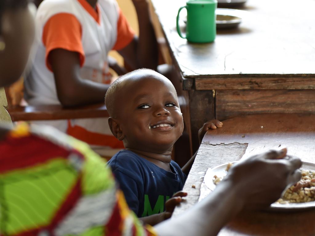 A child looks at its nanny as it takes a meal at the Saint Genevieve Welcome and Transit Centre for so-called 'cursed children', located in the northern town of Katiola, Ivory Coast, on November 4, 2016. AFP / ISSOUF SANOGO