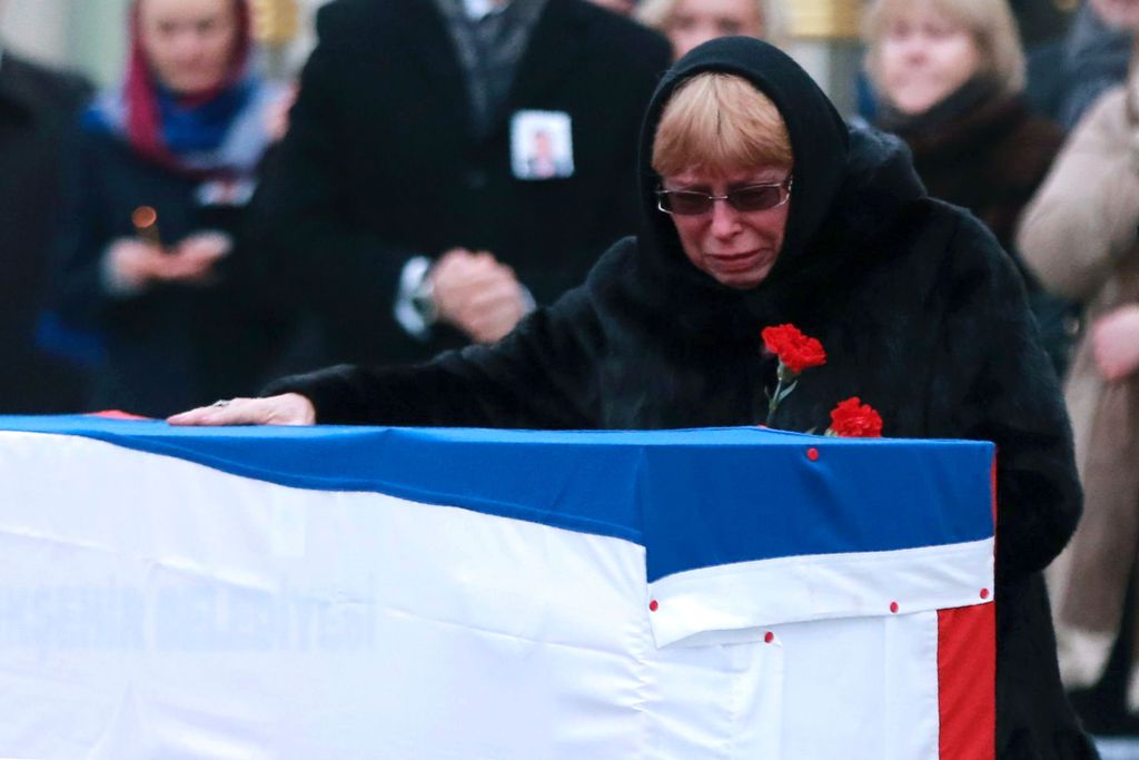 Marina Davydova Karlova, widow of late Russian Ambassador to Turkey Andrei Karlov, reacts in front of his coffin, during a ceremonial farewell with full state honours on the tarmac of Ankara's Esenboga Airport on December 20, 2016, before the coffin is tr