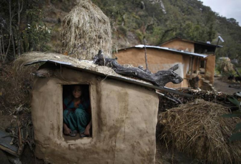 In this 2014 archive photo a 14-year old girl sits inside a Chaupadi shed in the hills of Legudsen village in Achham District in western Nepal. REUTERS/Navesh Chitrakar
