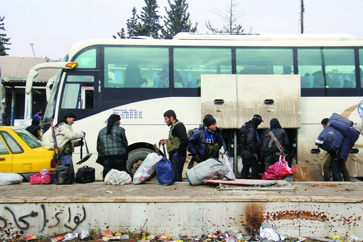 Syrian rebel fighters arrive in the opposition-controlled Khan Al Assal region, west of Aleppo, after being evacuated from the embattled city, yesterday.