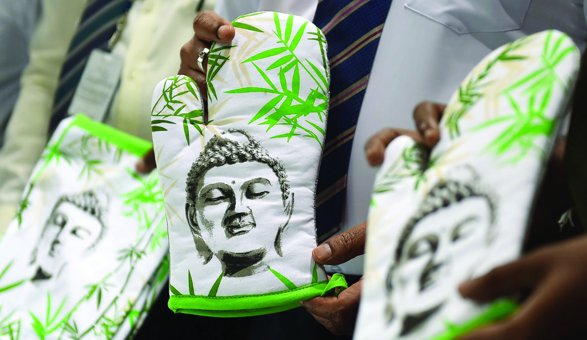 A Sri Lankan customs officer displays oven gloves from an impounded stock of kitchen aprons from India featuring images of the Buddha, in Colombo, yesterday.
