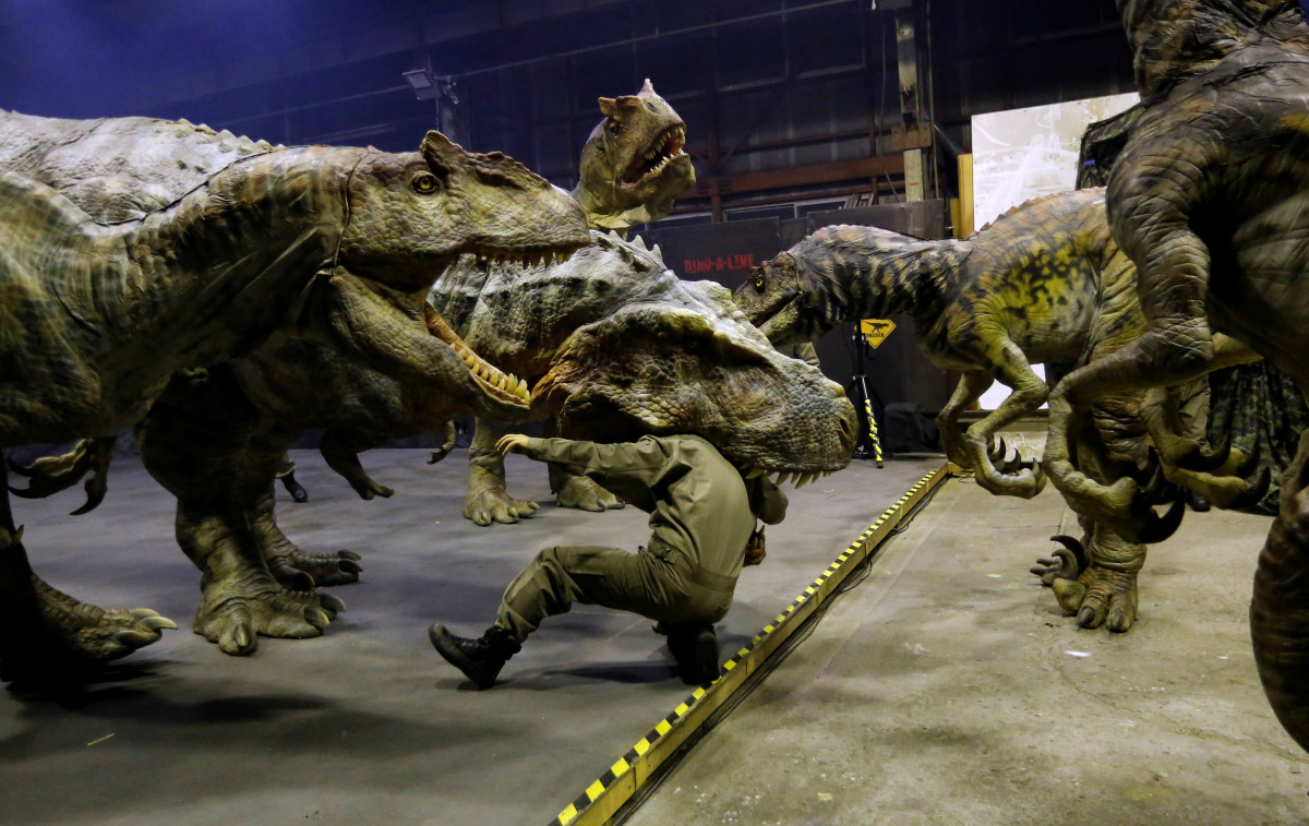 Japan's ON-ART Corp's eight metre tall human-operated walking dinosaur robot 'TRX03' (C) performs with other robots at the company's studio in Tokorozawa, Japan, December 6, 2016. REUTERS/Toru Hanai 