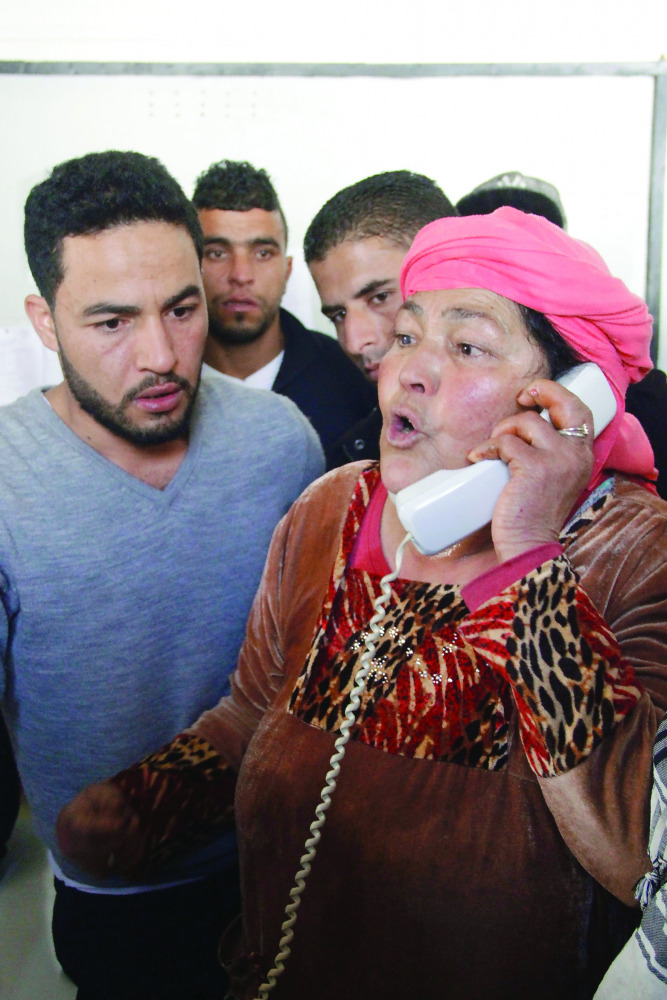 Nour-Houda Amri, the mother of Anis Amri, reacts during a phone call as her son Abdelkader looks on. 