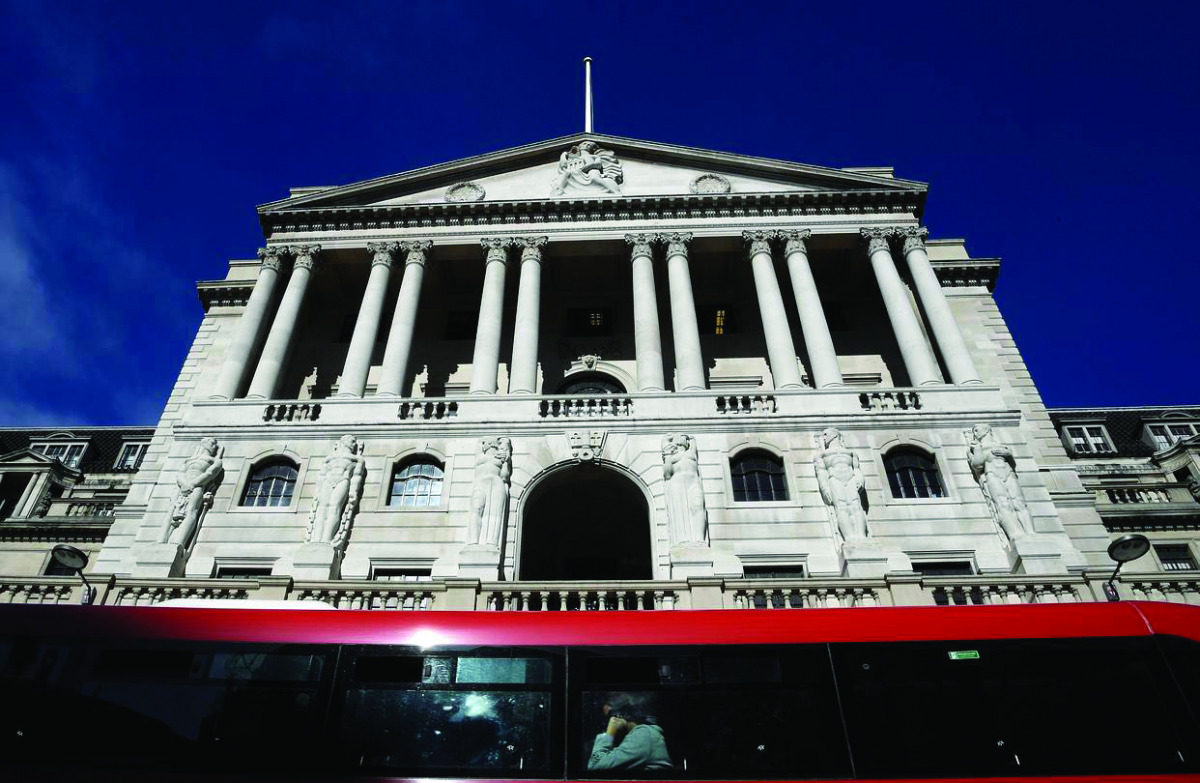 People travel on a bus as it passes the Bank of England in London.