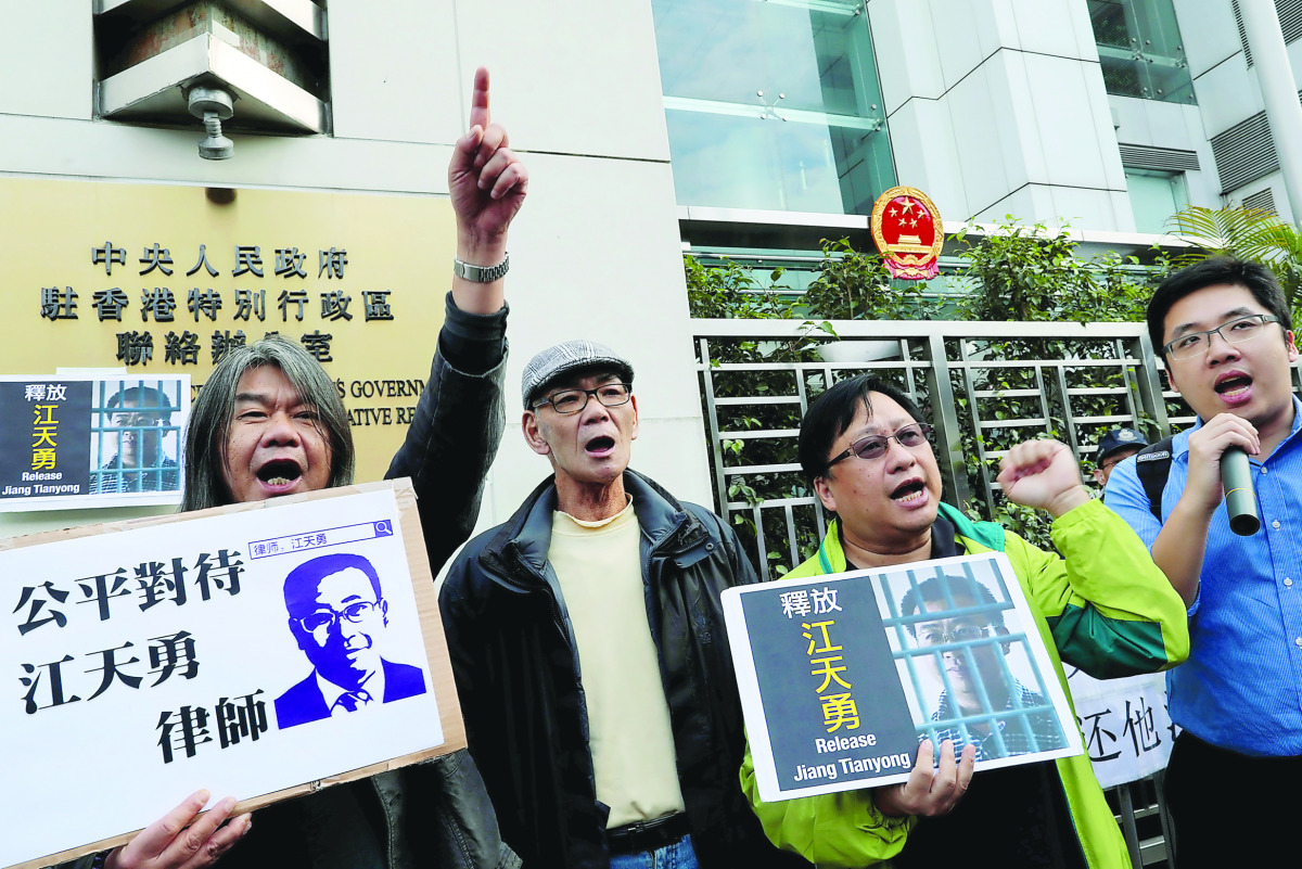 Pro-democracy demonstrators holding portraits of Chinese disbarred lawyer Jiang Tianyong, demanding his release, during a demonstration outside the Chinese Liaison Office in Hong Kong, yesterday.
