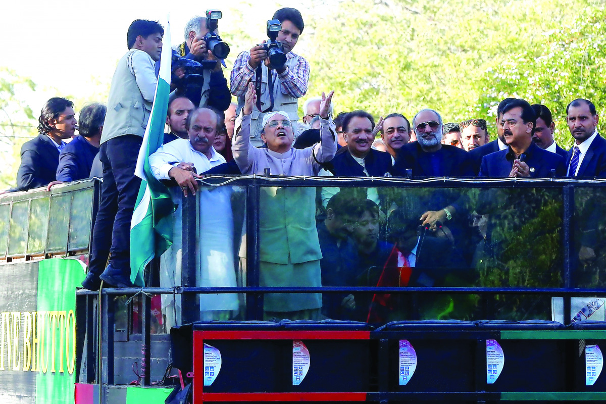 Asif Ali Zardari, former president of Pakistan and co-chairman of Pakistan People's Party (PPP), gestures to his supporters after returning from Dubai, at the Old Jinnah airport terminal in Karachi, yesterday.