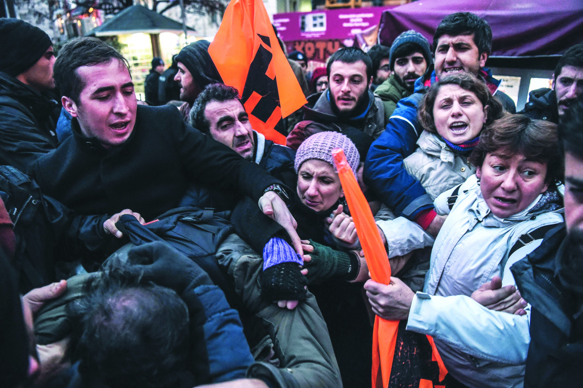 People scuffle as Turkish police detain protesters at Istiklal avenue in Istanbul, during a protest in reaction to a video released by the Islamic State group purportedly showing two captured Turkish soldiers being burned alive.