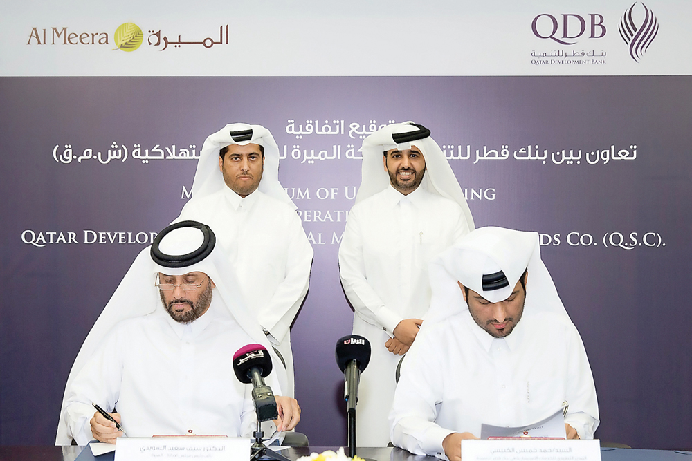 Abdulaziz bin Nasser Al Khalifa (standing right), CEO of QDB; and Chairman of the Board of Directors, Al Meera Company, Sheikh Thani bin Thamer bin Mohamed Al Thani, witnessing the MoU signing ceremony at QDB Headquarters in Doha recently. 