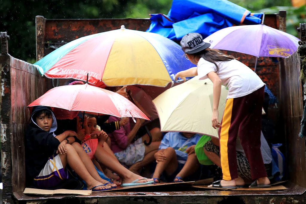 Young residents sit in a truck after the local government implemented preemptive evacuations at Barangay Matnog, Daraga, Albay province on December 25, 2016, due to the approaching typhoon Nock-Ten. Babies, toddlers and old people were loaded onto militar