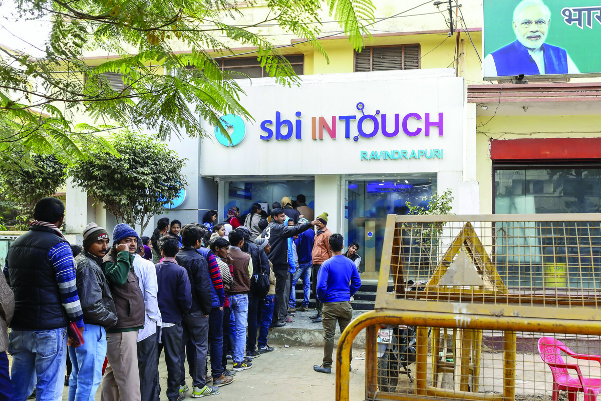 Customers wait in line at a branch of In Touch, operated by State Bank of India Ltd, in Varanasi, Uttar Pradesh.