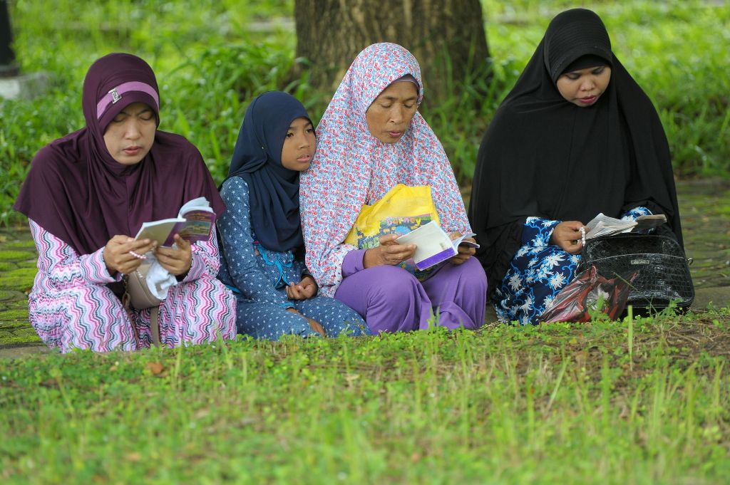 Family members gather to pray for their loved ones at a mass grave in Aceh on December 26, 2016, to mark the tsunami which devastated Aceh province 12 years ago in one of the worst natural disasters in human history. AFP / CHAIDEER MAHYUDDIN
