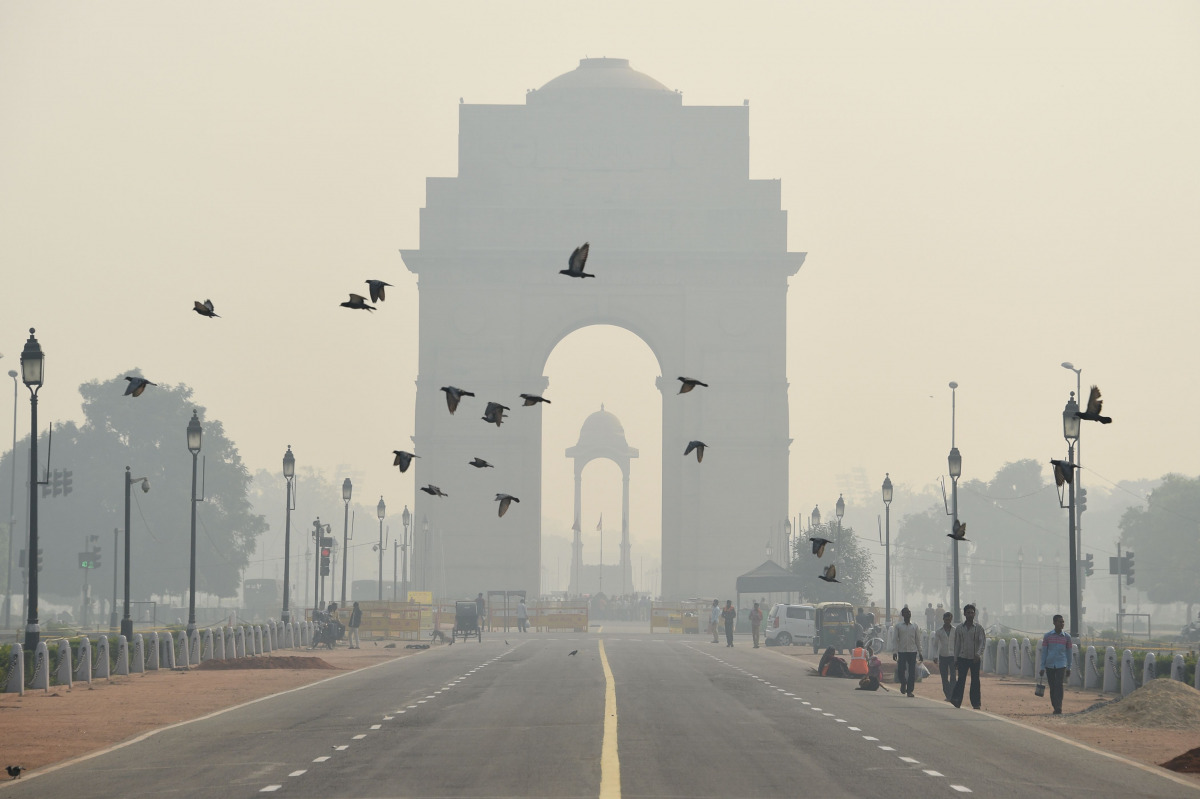 Indian pedestrians walk near the India Gate monument amid heavy smog in New Delhi October 28, 2016 (AFP)