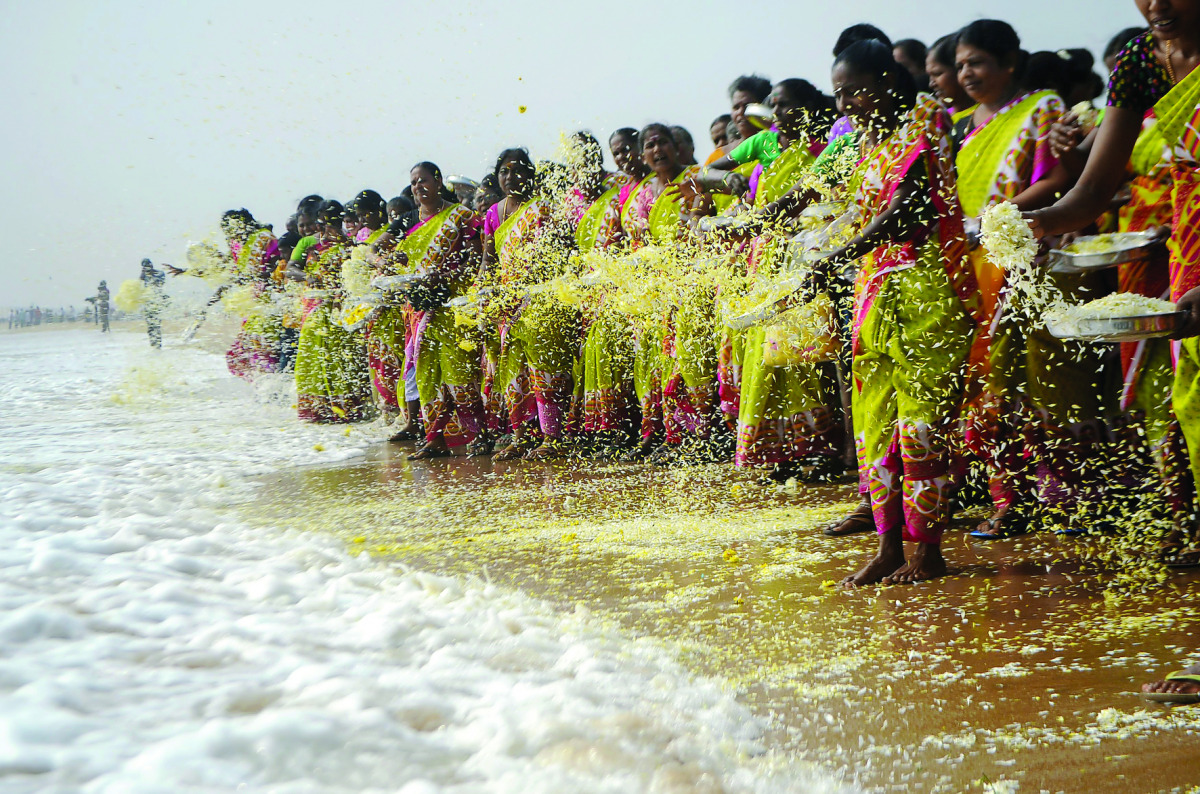 Women throw flowers into the sea as an offering during a ceremony for the victims of the 2004 tsunami at Marina Beach in Chennai yesterday.