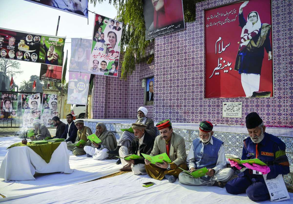 Supporters of Pakistan People's Party (PPP) of former Prime Minister, Benazir Bhutto, read the Holy Quran during a prayer ceremony held to mark her 9th death anniversary at Liaquat Bagh Park in Rawalpindi, Pakistan, yesterday.