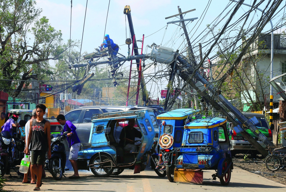 A worker fixes an electric post after it was damaged during Typhoon Nock-ten, in Iriga City, Camarines Sur, yesterday.