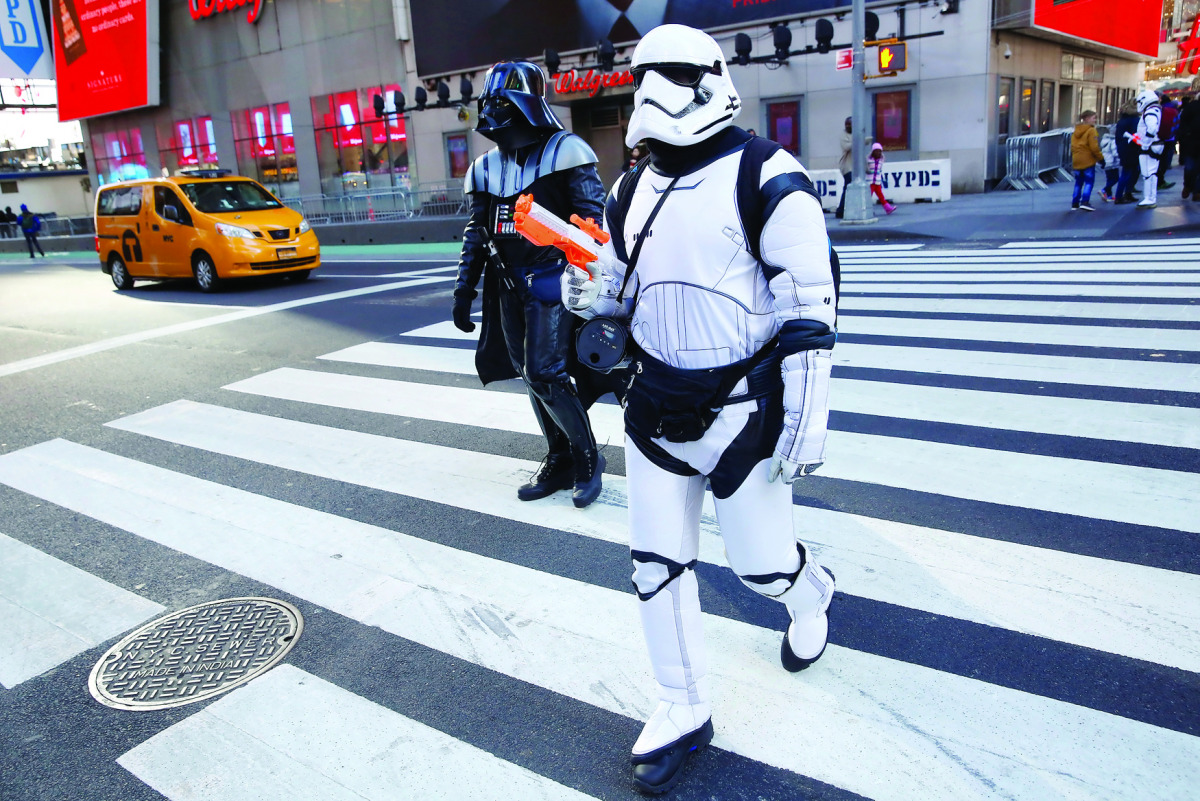 People dressed as Darth Vader and a Stormtrooper from Star Wars Rogue One walk at Times Square in Manhattan