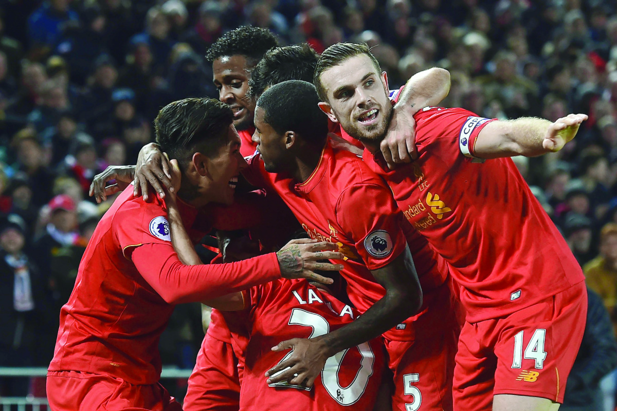 Liverpool's Roberto Firmino (left) celebrates with team-mates including Liverpool's Jordan Henderson (right) after scoring their second goal against Stoke City during their Premier League match at Anfield in Liverpool, England on Tuesday.
