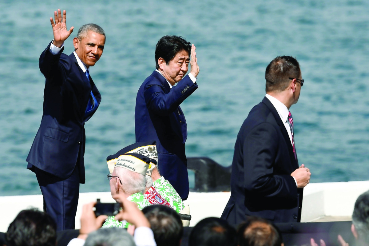 US President Barack Obama and Japanese Prime Minister Shinzo Abe wave to the crowd at Joint Base Pearl Harbor-Hickam in Honolulu, Hawaii, yesterday. 
