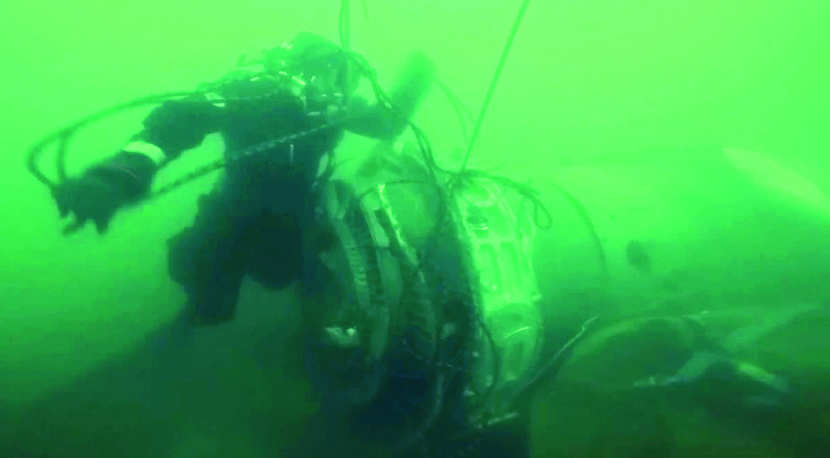 A diver looking at a piece of the crashed military plane during searches in the Black Sea outside Sochi, yesterday.