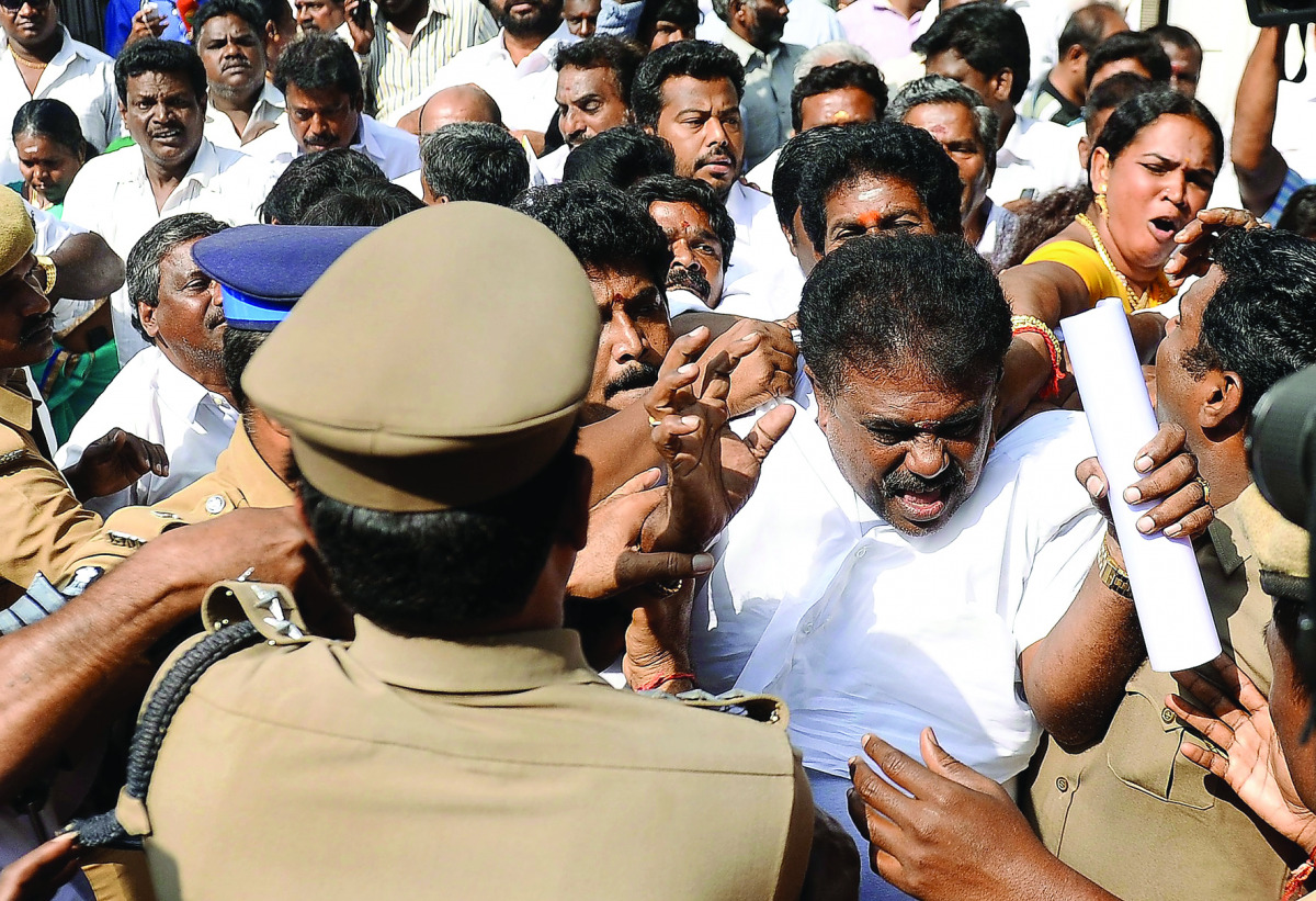 Members of the All India Anna Dravida Munnertra Kazhagam (AIADMK) preventing Rajya Sabha member Sasikala Pushpa's husband Lingeswara Thilagan from entering the party's office in Chennai, yesterday.