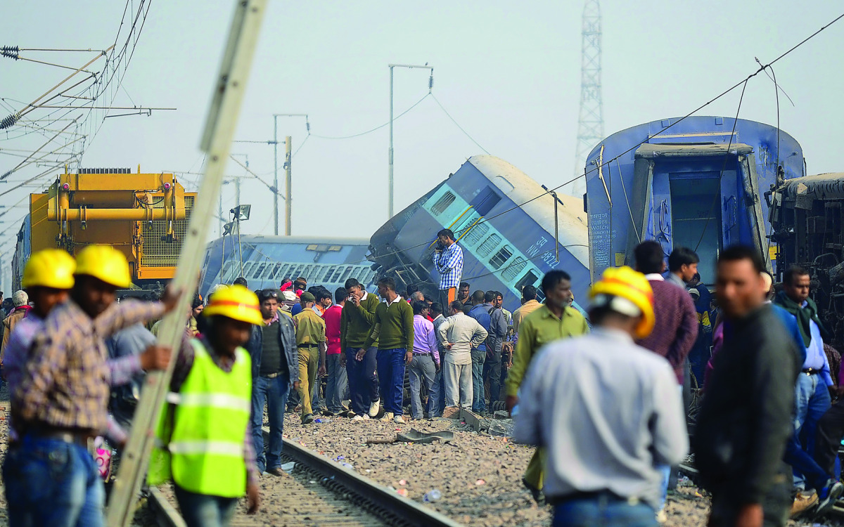 Police officials and bystanders gathering at the derailed train carriages in Rura, near Kanpur,  yesterday.