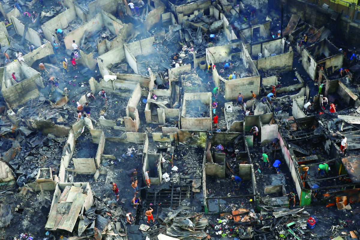 Residents sift through the ruins of their houses after a fire razed a squatter colony, in Quezon city, Metro Manila in the Philippines December 28, 2016. REUTERS/Erik De Castro