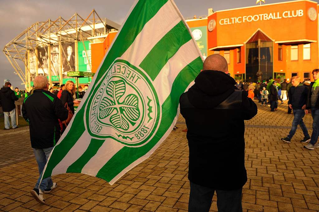 A Celtic fan with a flag stands outside Celtic Park in Glasgow on December 17, 2016 before the Scottish Premiership football match between Celtic and Dundee United.  AFP / ANDY BUCHANAN 
