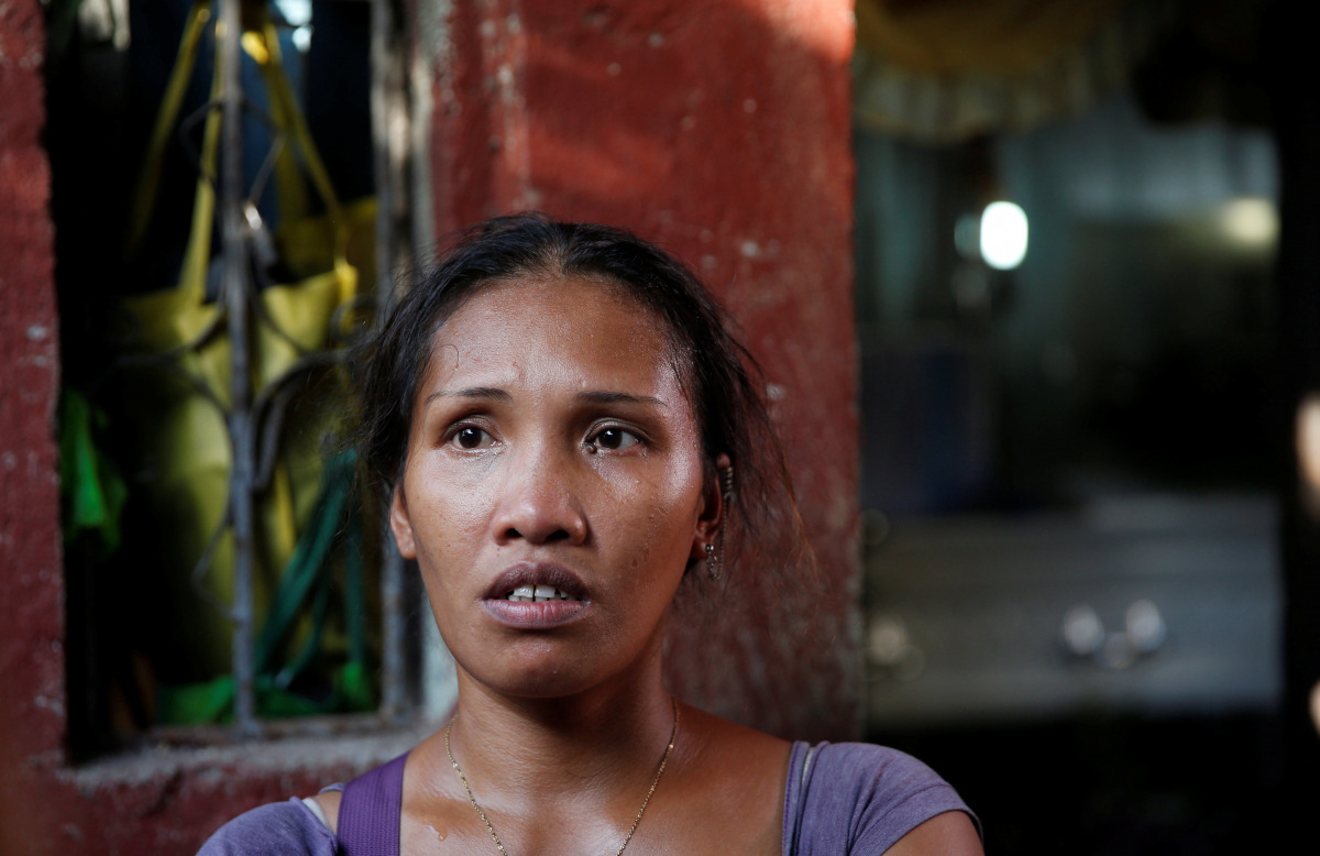 Jona speaks to reporters at the entrance of her house near the coffin of her son Jonel Segovia, who was shot dead by suspected vigilantes at a house storing illegal narcotics, police said on Thursday, in Caloocan city, Metro Manila, in the Philippines Dec